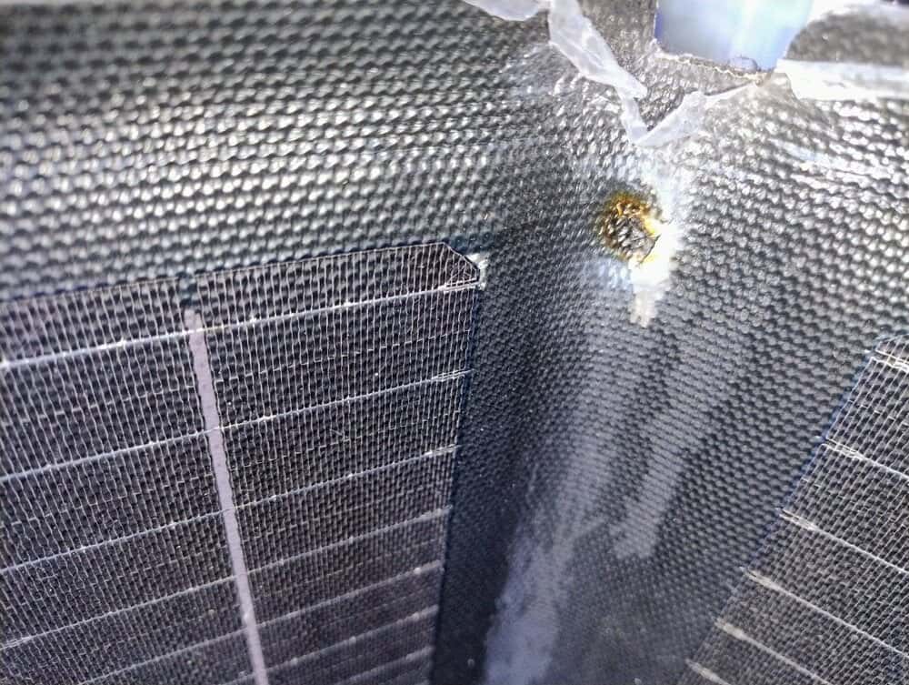 A broken, bulky, or water-damaged portable solar panel, showing the pain points of low-quality outdoor gear.