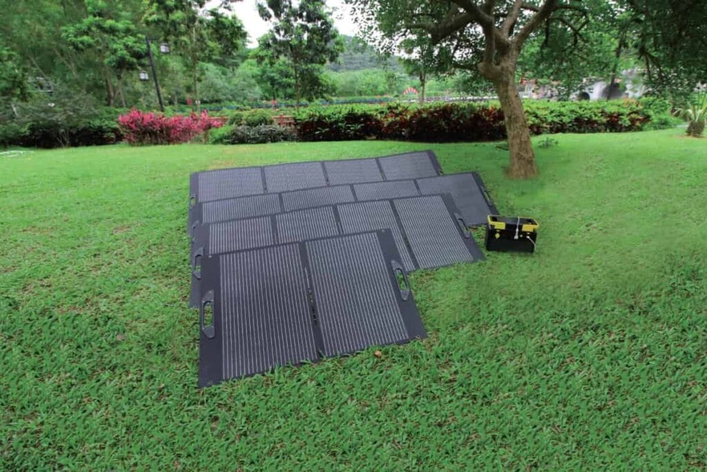 Sola-E foldable solar panel spread out on grass for camping power generation.