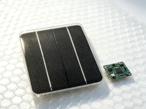 Close-up of a 1.5W ETFE small solar panel next to an IoT circuit board showing high-end surface texture.