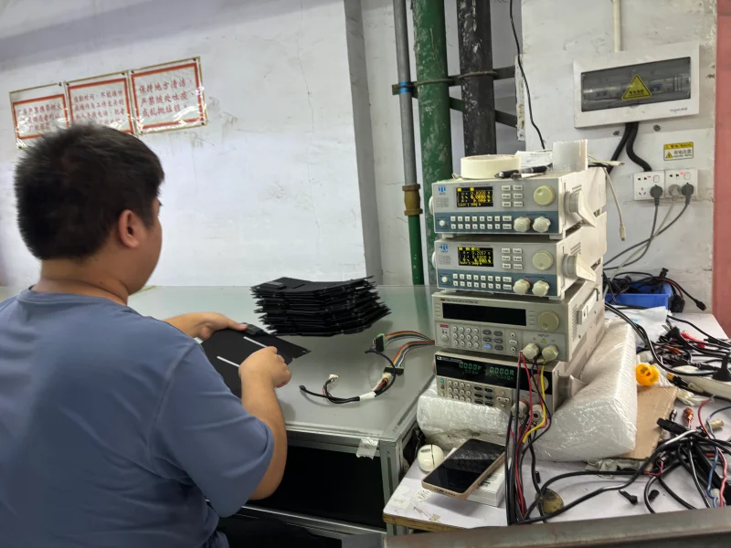 Technician performing EL quality testing on a flexible solar panel