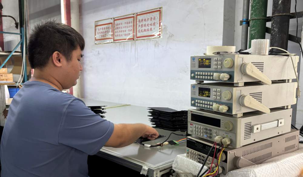 Technician conducting electrical quality-control checks on a foldable solar panel